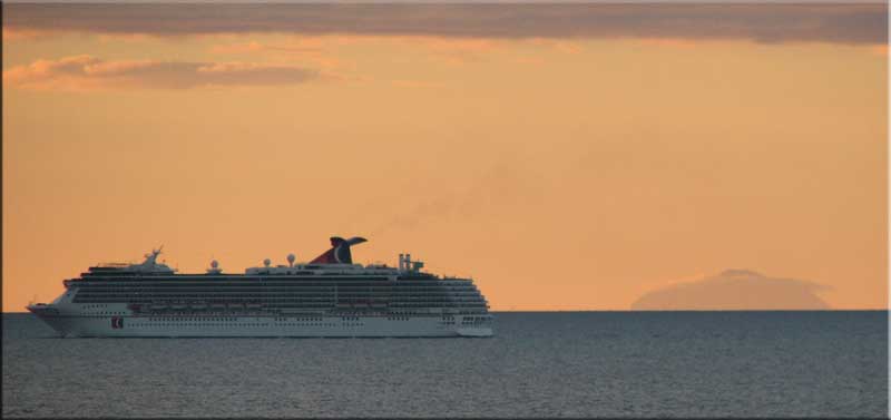 A cruise ship and Nevis on a clear morning